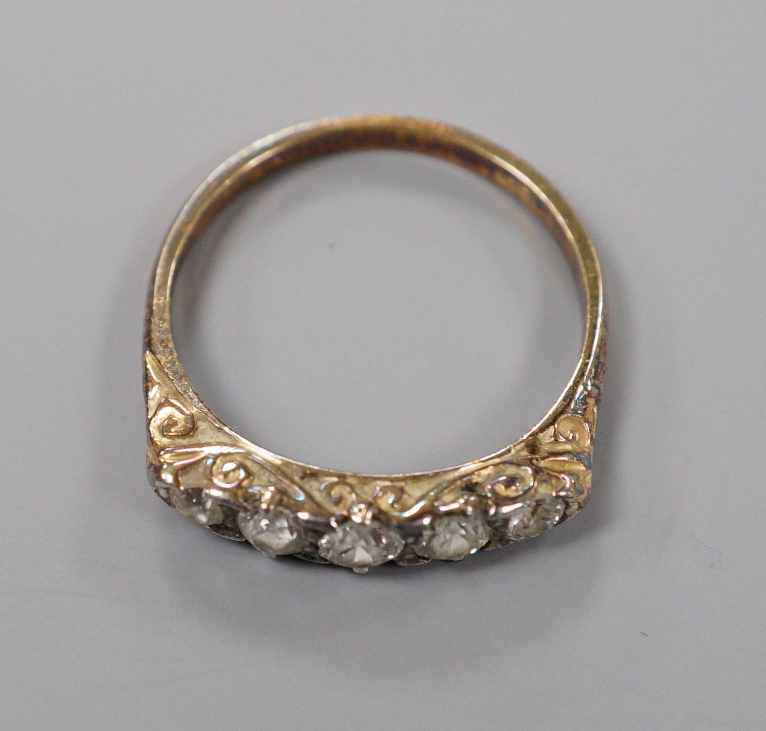 An early 20th century 18ct and graduated five stone diamond set half hoop ring, size P/Q, gross weight 2.7 grams.
